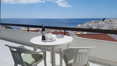 a white table and chairs on a balcony with the ocean at Albufeira Ocean Terrace (31) in Albufeira