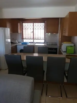 a kitchen with a table and chairs in it at Apartamento Solar dos Pinheiros in Vilamoura