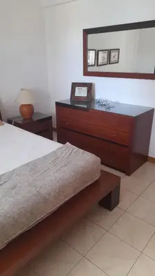 a bedroom with a bed and a dresser with a mirror at Apartamento Solar dos Pinheiros in Vilamoura