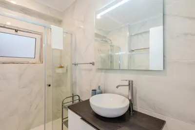 a bathroom with a sink and a glass shower at Vista Mar in Quarteira