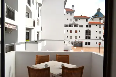 a table and chairs on a balcony with a view of a building at Algardia Marina Parque by Garvetur in Vilamoura