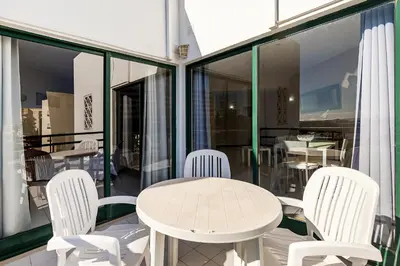 a white table and chairs on a balcony at Algamar by Garvetur in Vilamoura