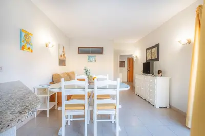 a kitchen and dining room with a white table and chairs at Algamar by Garvetur in Vilamoura