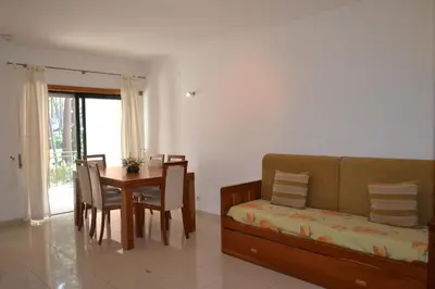 a living room with a couch and a dining room table at Eden Vilage by Garvetur in Vilamoura