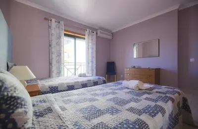 a bedroom with two beds with a dog laying on the bed at Eden Vilage by Garvetur in Vilamoura