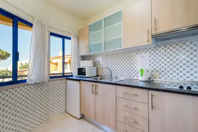 a kitchen with a sink and a microwave at Rio by Garvetur in Vilamoura