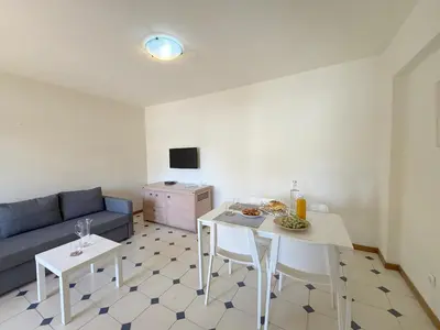 a living room with a couch and a table and chairs at Rio by Garvetur in Vilamoura