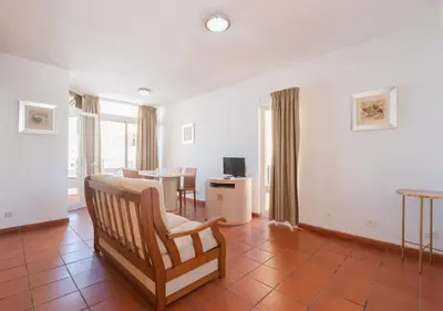 a bedroom with a bed and a dining room at Marina Plaza by Garvetur in Vilamoura