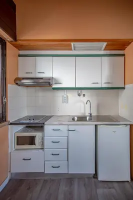 a kitchen with white cabinets and a sink at Turial Old Town Ocean View in Albufeira