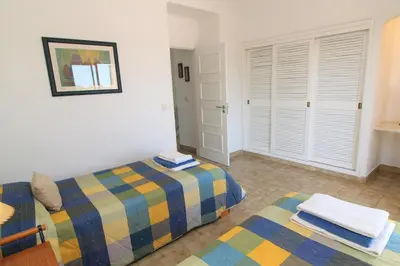 a bedroom with two twin beds and a window at Apartamento 53A São Rafael T2 duplex - Albufeira, Algarve in Albufeira