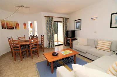a living room with a couch and a table at Apartamento 53A São Rafael T2 duplex - Albufeira, Algarve in Albufeira