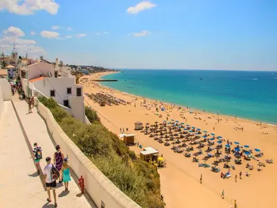a building on a beach with chairs and a building at V4, Villa Jardins Branqueira4 near Beach, Albufeira in Albufeira
