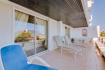a patio with chairs and a table on a balcony at São Vicente - 1Br - Facing to Marina in Quarteira