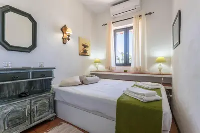 a bedroom with a bed and a mirror and a window at Villa Morena in Albufeira