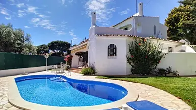 a villa with a swimming pool in front of a house at Villa Palmeira Galé Beach in Albufeira