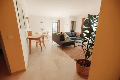 a living room with a couch and a plant at Casa Velha Apartments - Adults friendly in Albufeira