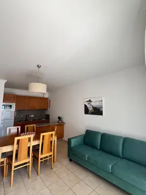 a living room with a table and a couch at Albufeira Mar Vilas in Albufeira