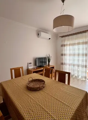 a living room with a couch and a table and chairs at Albufeira Mar Vilas in Albufeira