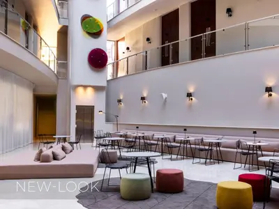 a lobby with tables and chairs in a building at Aqua Pedra Dos Bicos Design Beach Hotel - Adults Friendly in Albufeira