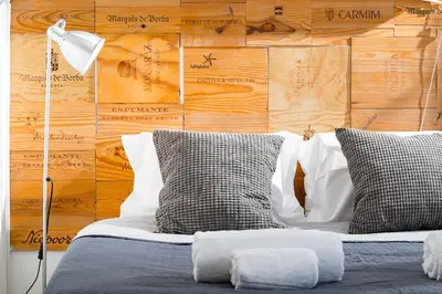a bed with two pillows in front of a wooden wall at Beautiful Rooftop, Vilamoura in Quarteira