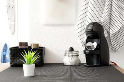 a black coffee maker sitting on a floor with a plant at Beautiful Rooftop, Vilamoura in Quarteira