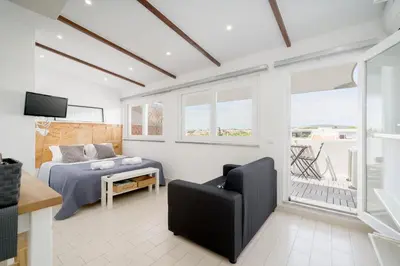a bedroom with a bed and a couch and a tv at Beautiful Rooftop, Vilamoura in Quarteira
