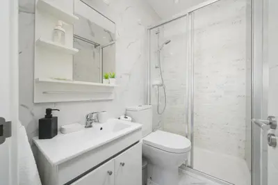 a white bathroom with a toilet and a shower at Beautiful Rooftop, Vilamoura in Quarteira