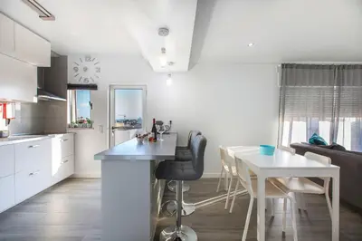 a kitchen and a living room with a table and a counter at Maria Rita Faro Rooftop Apartment in Faro