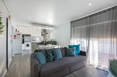 a living room with a couch and a kitchen at Maria Rita Faro Rooftop Apartment in Faro
