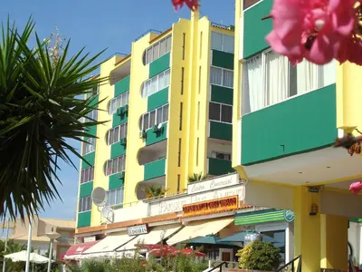 a yellow and green building with pink flowers in front of it at Parque das Amendoeiras in Vilamoura