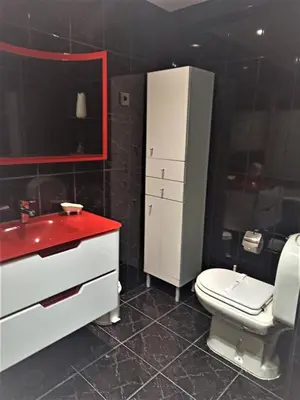 a bathroom with a white toilet and a red sink at Parque das Amendoeiras in Vilamoura