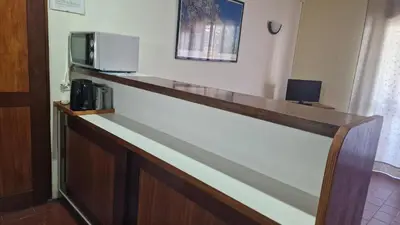 a bar in a hotel room with a microwave at Parque das Amendoeiras in Vilamoura