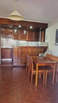 a kitchen with a wooden table and chairs at Parque das Amendoeiras in Vilamoura