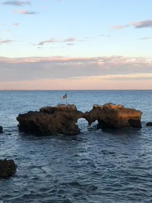 two rocks in the ocean with a flag on top at magnifique appartement sur la plage ... in Albufeira