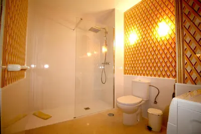 a bathroom with a shower with a toilet and a glass shower stall at magnifique appartement sur la plage ... in Albufeira