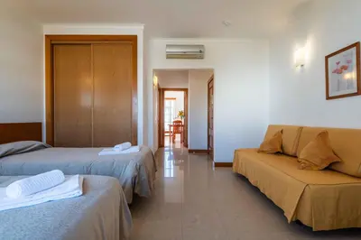 a hotel room with two beds and a couch at Apartamentos Monte da Vinha I in Albufeira