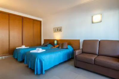 a hotel room with two beds and a couch at Apartamentos Turisticos Monte da Vinha II in Albufeira