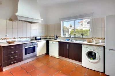 a kitchen with a washing machine and a washer at Villa Francella- Relaxing holidays in an ideal location by DreamvillasAlbufeira in Albufeira