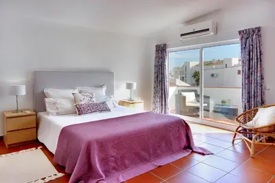a bedroom with a bed and a large window at Villa Francella- Relaxing holidays in an ideal location by DreamvillasAlbufeira in Albufeira
