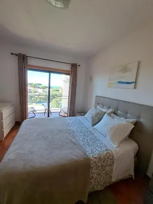 a bedroom with a bed and a large window at Charming Ocean View Apartment in Albufeira