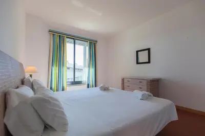 a bedroom with a white bed and a window at Residence Golf Club by Garvetur in Vilamoura