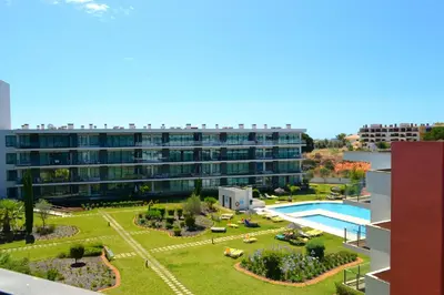 a large apartment building with a large garden and a swimming pool at Residence Golf Club by Garvetur in Vilamoura