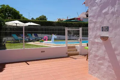 a fence around a swimming pool with an umbrella at LOTUS VILLA, Albufeira in Albufeira