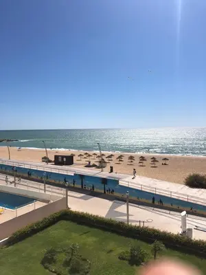 a view of the beach from the balcony of a resort at Apartment Girasol Front Beach Quarteira Algarve in Quarteira