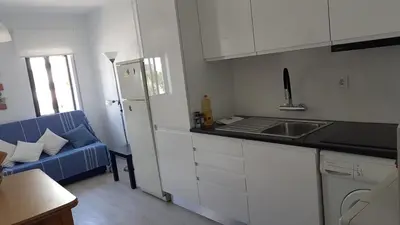 a kitchen with a blue couch in a room at Apartment Girasol Front Beach Quarteira Algarve in Quarteira