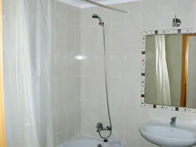 a bathroom with a shower and a sink and a mirror at Welcoming apartment in Albufeira 60 m² with shared pool in Albufeira