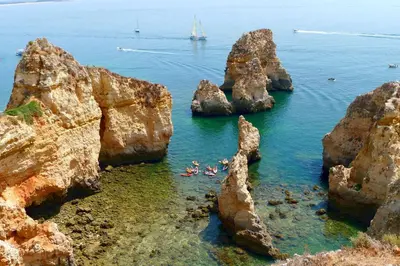 a group of people in the water near some rocks at Charming apartment with shared pool in Albufeira - 60 m² in Albufeira
