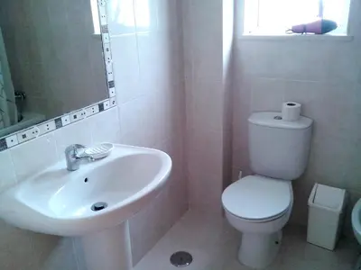 a white bathroom with a toilet and a sink at Charming Apartment in Albufeira - 60 m² with pool & view in Albufeira