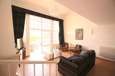 a living room with a couch and a table at magnifique maison en resort près des plages in Albufeira