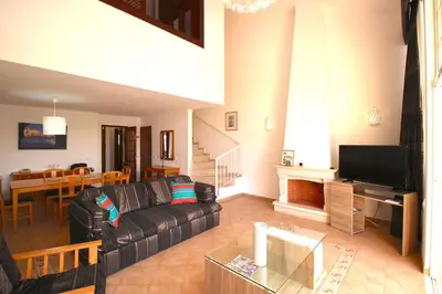 a living room with a couch and a dining room at magnifique maison en resort près des plages in Albufeira